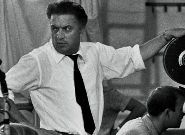 black and white photo of Federico Fellini on film set of 8 1/2